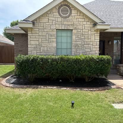 Trimmed shrubs and a maintained lawn outside an Abilene-area home