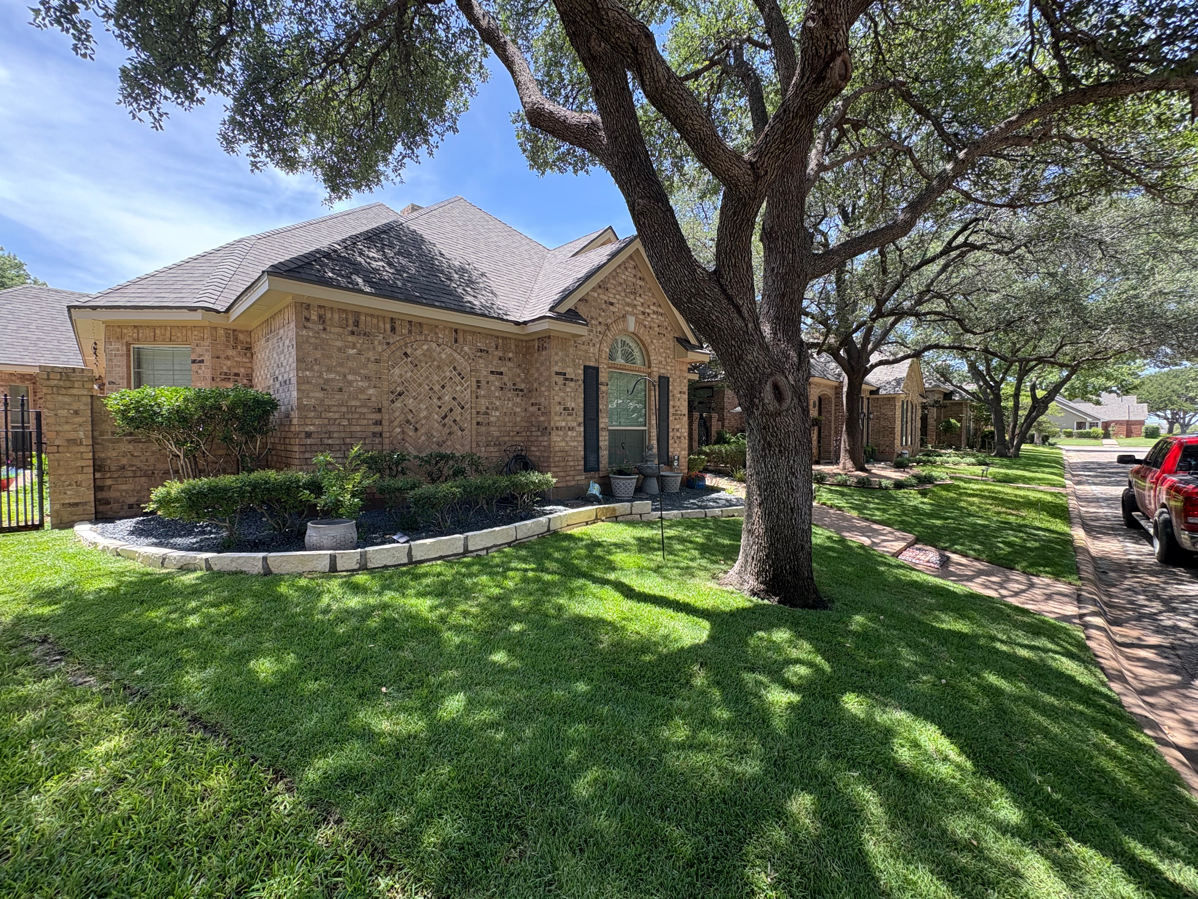 Freshly maintained lawn and landscaped flowerbeds at an Abilene home