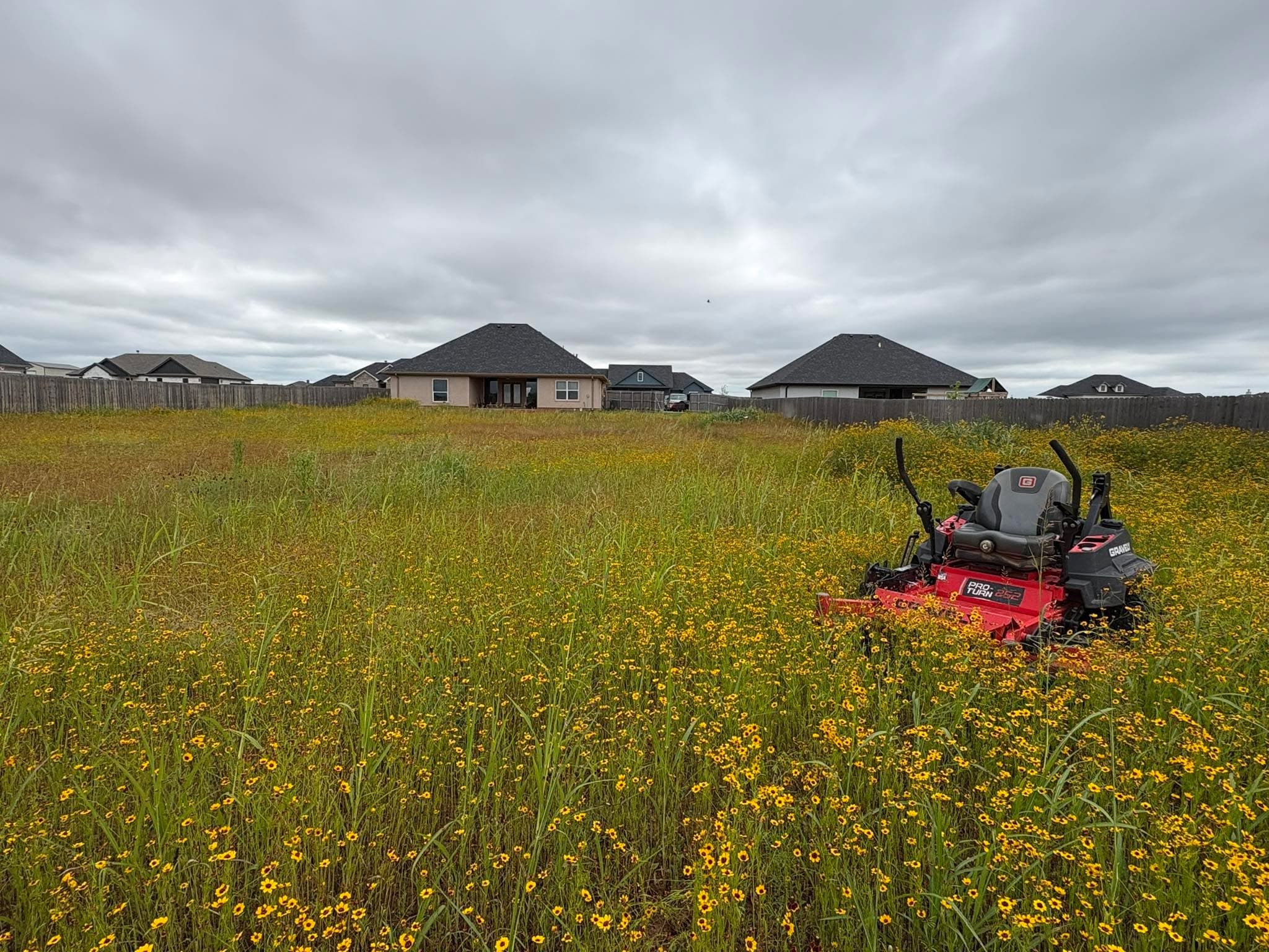 Red Outwest commercial mower on a large Abilene property ready for scheduled grounds maintenance