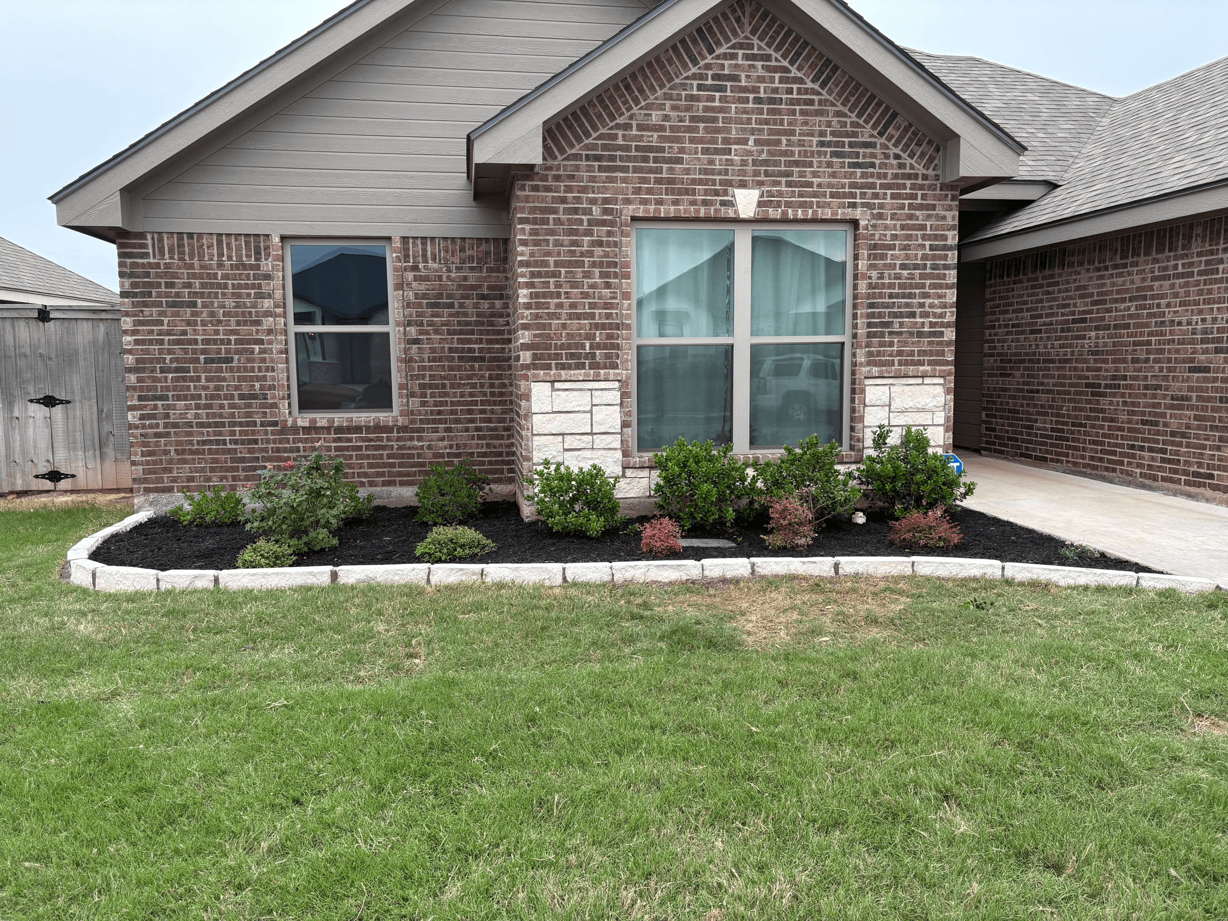 Landscaped yard with clean beds and a freshly maintained lawn