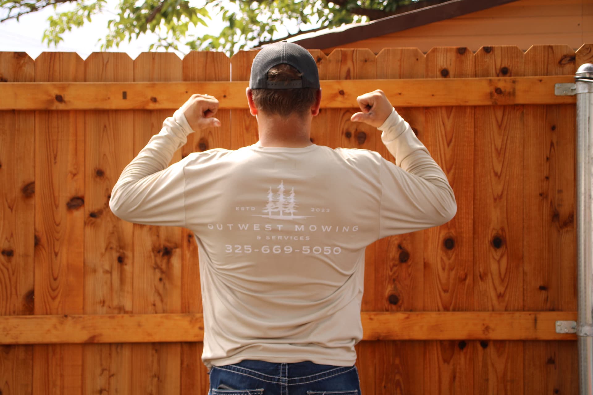 Outwest Mowing team member wearing a branded work shirt